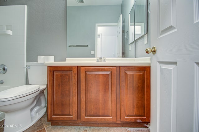 bathroom with toilet, vanity, and tile patterned floors