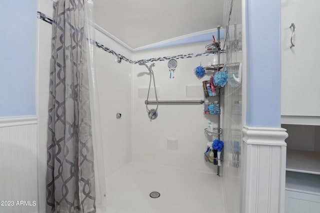 full bath featuring a wainscoted wall and curtained shower