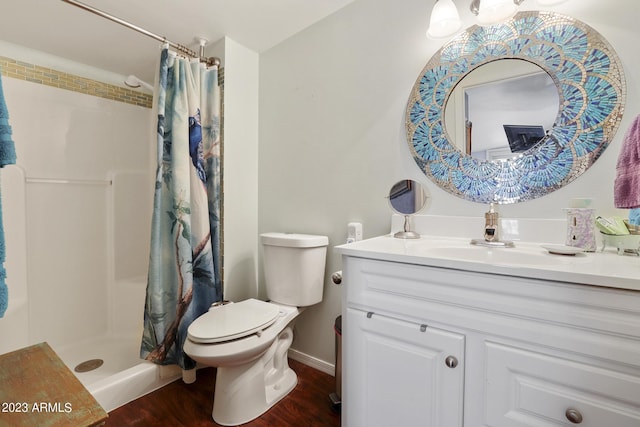 full bath featuring vanity, a shower stall, toilet, and wood finished floors