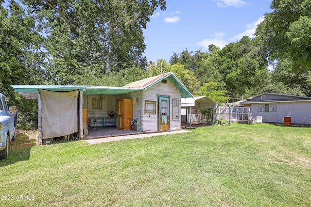 rear view of house with a carport, metal roof, and a yard