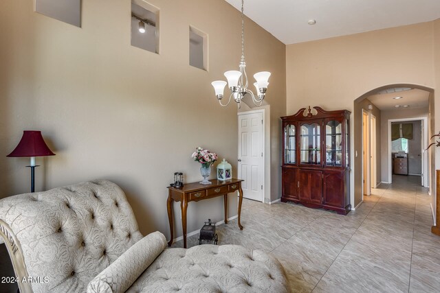 sitting room with a high ceiling and an inviting chandelier