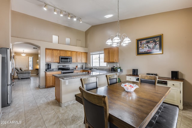 dining space with high vaulted ceiling, a notable chandelier, and sink