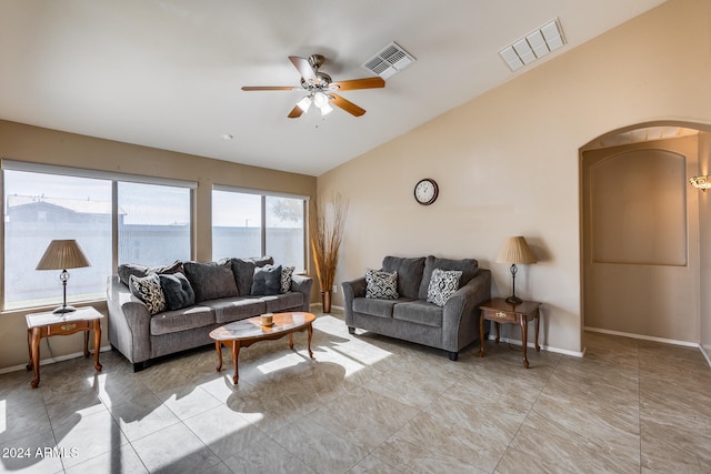 living room with ceiling fan, a water view, and vaulted ceiling