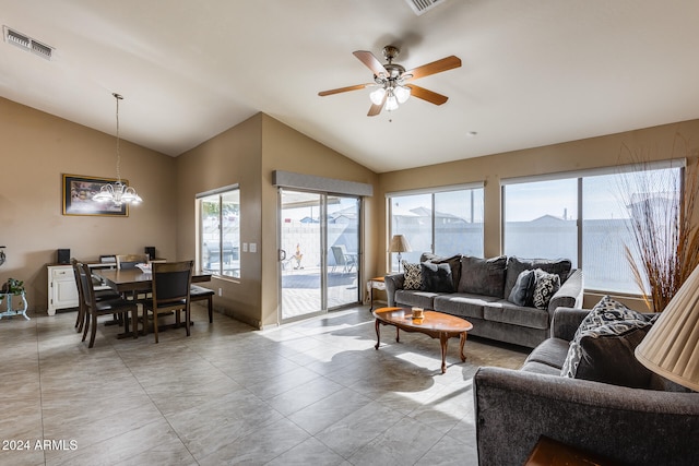 living room with light tile patterned floors, ceiling fan with notable chandelier, and vaulted ceiling