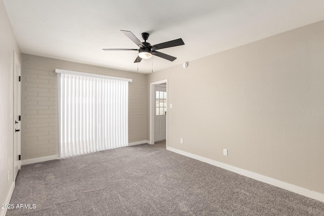 unfurnished room with a ceiling fan, carpet flooring, and baseboards