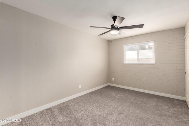 carpeted empty room with ceiling fan and baseboards