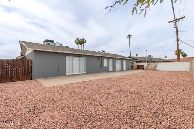 rear view of property with a patio area, brick siding, and a fenced backyard