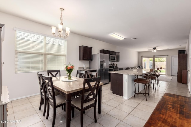 dining room with ceiling fan with notable chandelier and light tile patterned floors