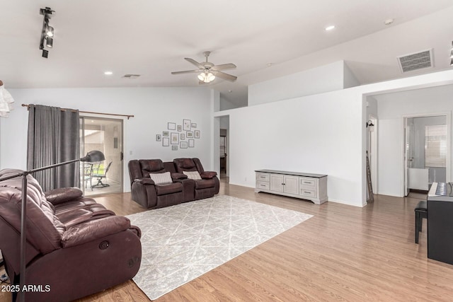 living area featuring light wood-style floors, visible vents, vaulted ceiling, and a ceiling fan