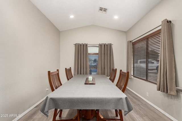 dining area with lofted ceiling, light wood-style floors, baseboards, and visible vents