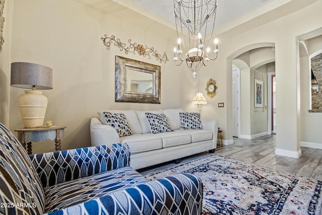 28019 N 115th Pl, Scottsdale, AZ 85262 - living room with arched walkways, wood finished floors, baseboards, and a chandelier