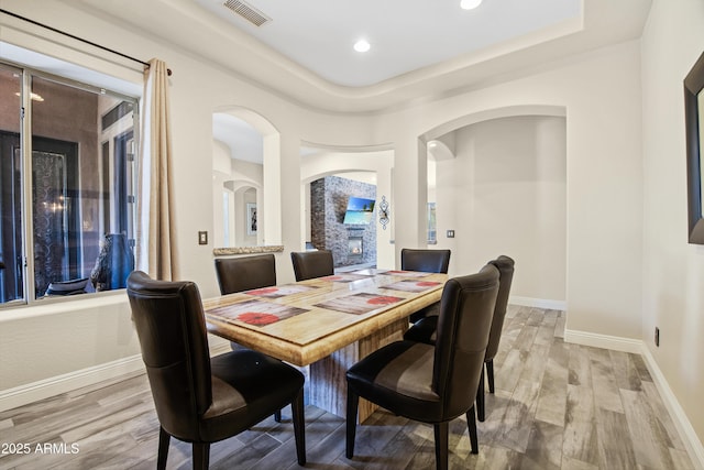 28019 N 115th Pl, Scottsdale, AZ 85262 - dining room featuring arched walkways, light wood finished floors, baseboards, a tray ceiling, and recessed lighting