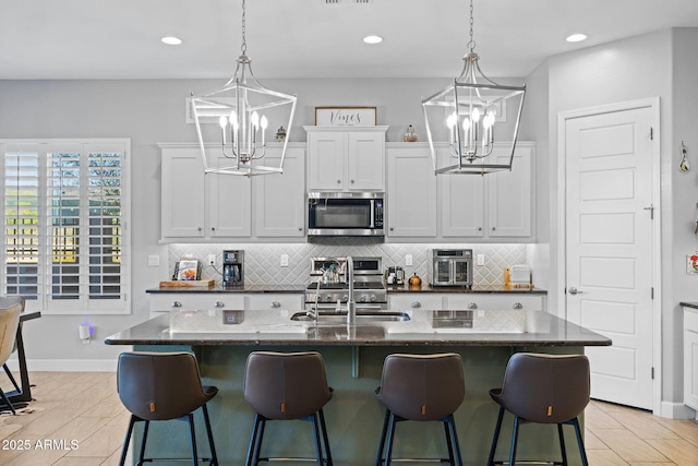 6948 E Quill St, Mesa, AZ 85207 - kitchen with stainless steel microwave, a chandelier, a sink, backsplash, and recessed lighting