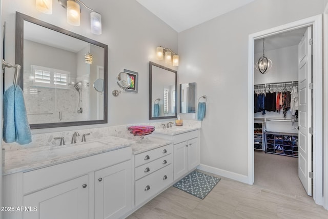 6948 E Quill St, Mesa, AZ 85207 - bathroom with double vanity, an enclosed shower, a walk in closet, and baseboards