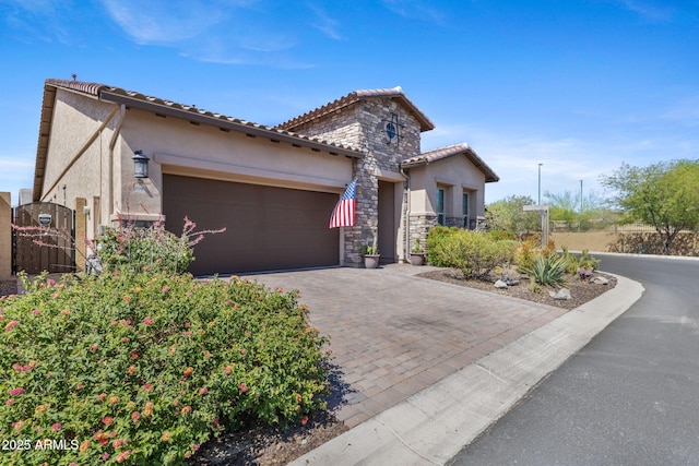 6948 E Quill St, Mesa, AZ 85207 - mediterranean / spanish house with a gate, stone siding, stucco siding, a garage, and decorative driveway