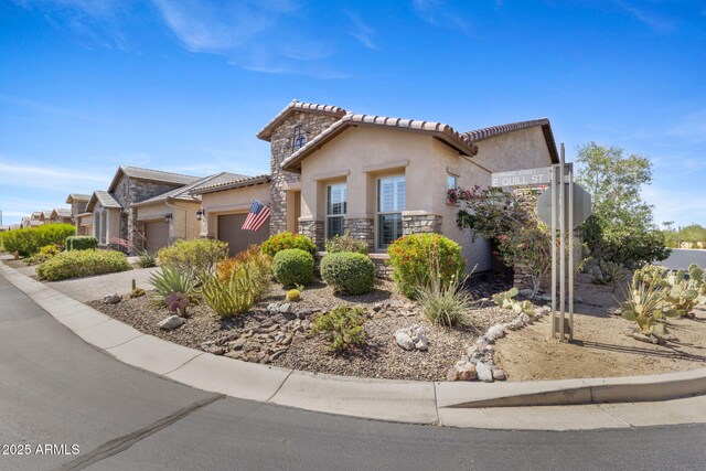 6948 E Quill St, Mesa, AZ 85207 - mediterranean / spanish house featuring stone siding, an attached garage, stucco siding, and a tile roof