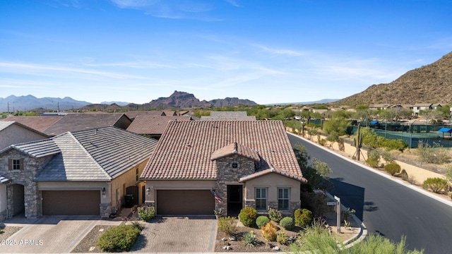 6948 E Quill St, Mesa, AZ 85207 - view of front of home featuring stone siding, stucco siding, a tiled roof, and an attached garage