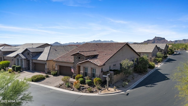 6948 E Quill St, Mesa, AZ 85207 - view of front facade with stucco siding, a garage, a mountain view, a tile roof, and stone siding