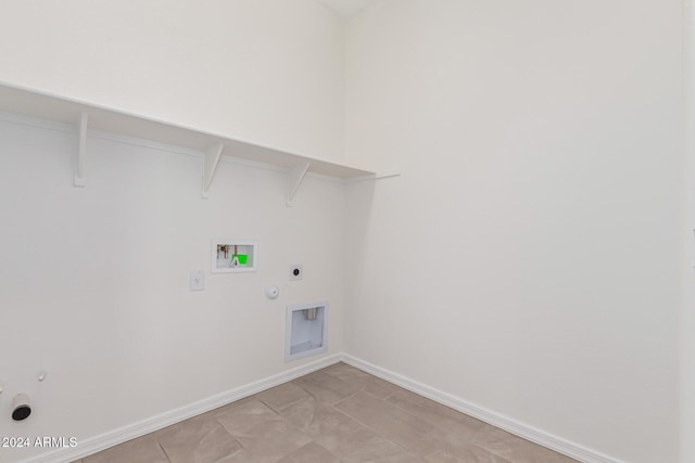 washroom featuring hookup for a gas dryer, light tile patterned flooring, washer hookup, and hookup for an electric dryer