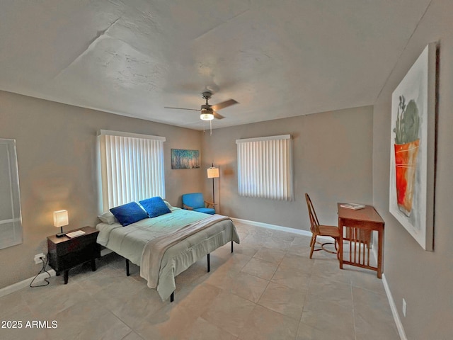 bedroom with light tile patterned floors, baseboards, and a ceiling fan