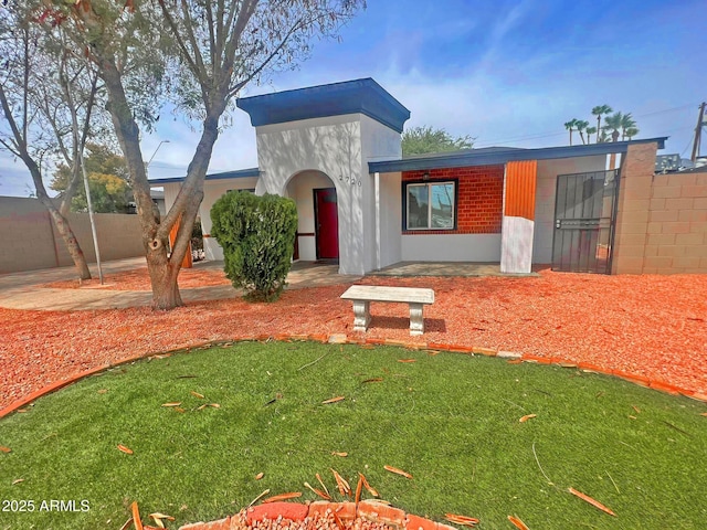 view of front facade featuring a front yard and fence