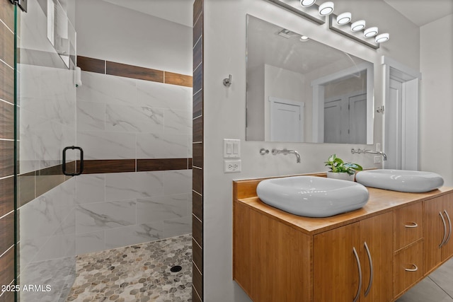 full bathroom featuring a sink, a shower stall, and double vanity