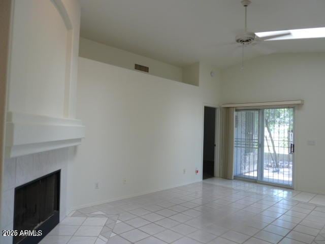 unfurnished living room with light tile patterned floors, visible vents, lofted ceiling, ceiling fan, and a large fireplace