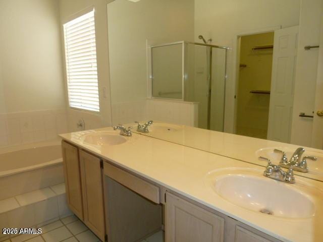 full bathroom featuring double vanity, a bath, a stall shower, and a sink