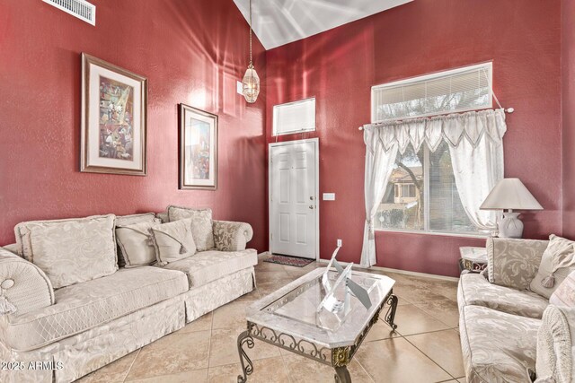 tiled living room with a high ceiling and visible vents