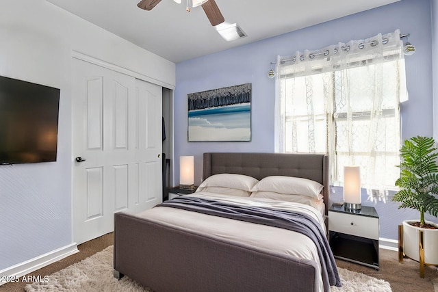 carpeted bedroom featuring a closet, ceiling fan, and baseboards