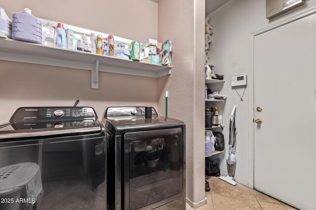 laundry room with tile patterned floors, washing machine and dryer, and laundry area