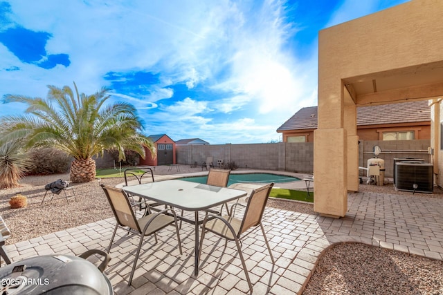 view of patio / terrace featuring central AC unit, outdoor dining area, a fenced backyard, and a fenced in pool