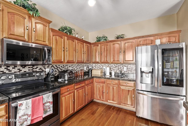 kitchen with stainless steel appliances, brown cabinets, tasteful backsplash, and wood finished floors