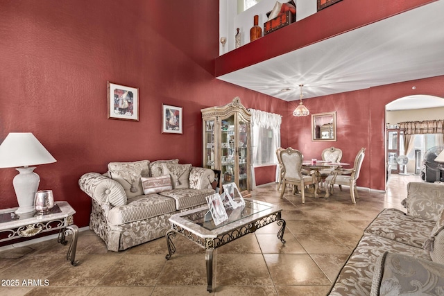 living area featuring arched walkways and a high ceiling
