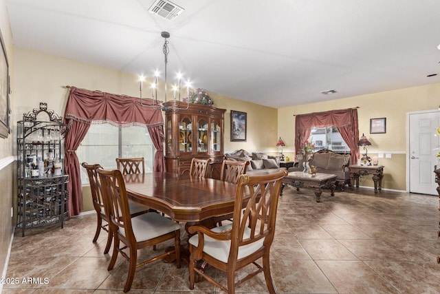 dining room featuring tile patterned flooring and a chandelier