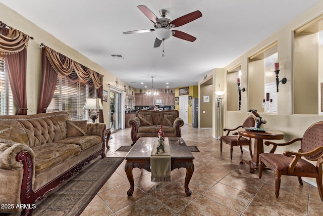 living room featuring tile patterned floors and ceiling fan with notable chandelier