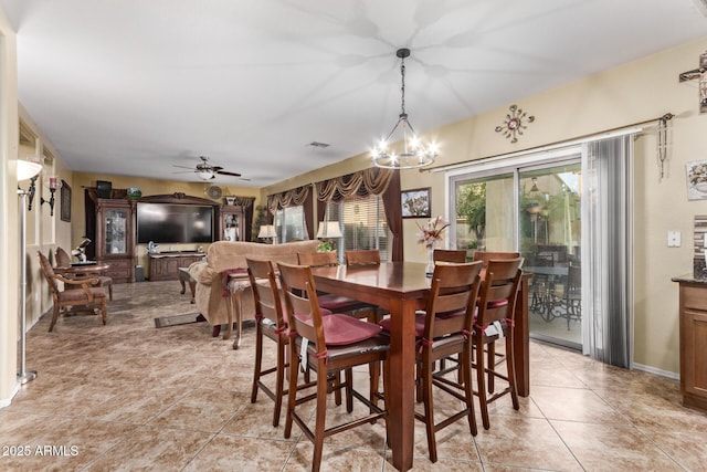 dining area featuring light tile patterned floors and ceiling fan with notable chandelier