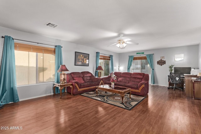 living room featuring ceiling fan and dark wood-type flooring