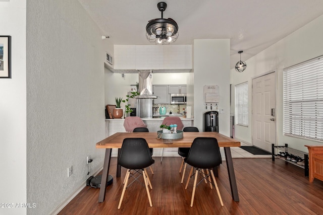 dining area with ceiling fan and dark hardwood / wood-style flooring