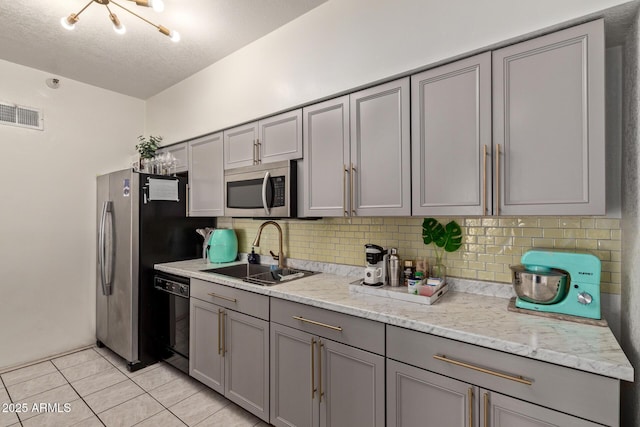 kitchen with sink, black dishwasher, gray cabinetry, and a textured ceiling