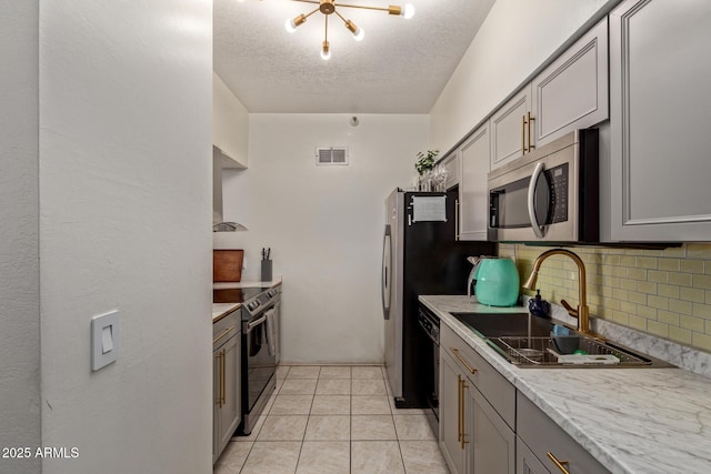 kitchen with gray cabinetry, a textured ceiling, sink, electric range oven, and tasteful backsplash