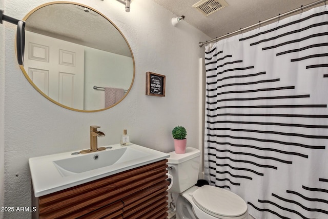 bathroom featuring toilet, vanity, a textured ceiling, and curtained shower