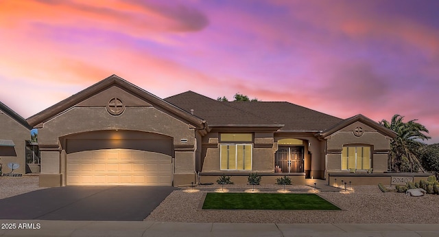 view of front of house with a garage, concrete driveway, and stucco siding