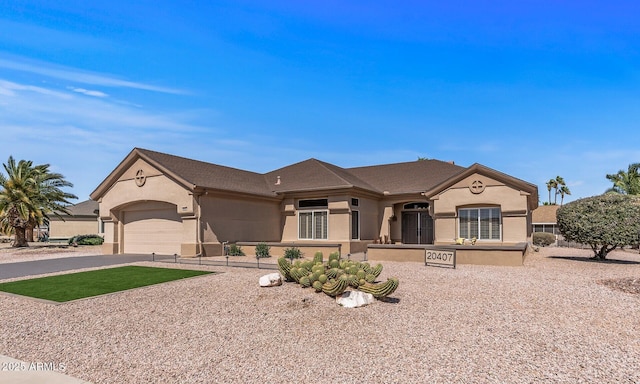 view of front of house featuring a garage, driveway, and stucco siding