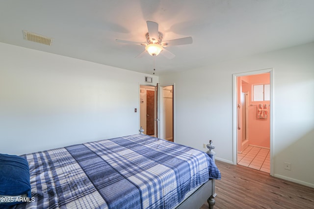 bedroom featuring hardwood / wood-style flooring, ceiling fan, and connected bathroom