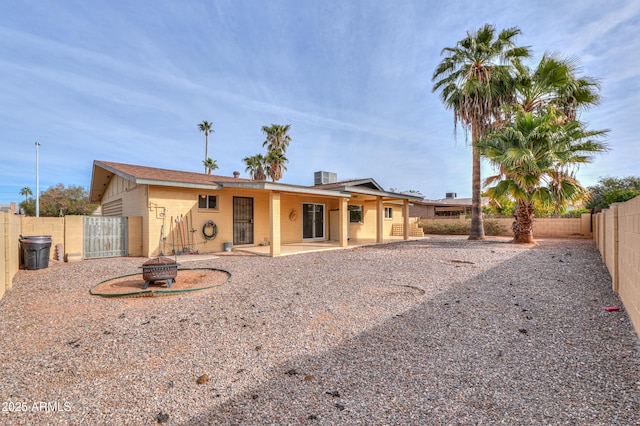 rear view of house featuring a fire pit and a patio