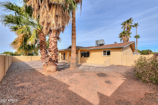 back of property with central AC and a patio area