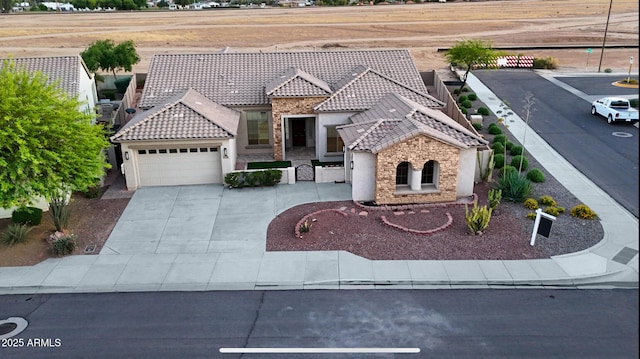 18027 W Royal Palm Rd, Waddell, AZ 85355 - view of front of home with stone siding, a tiled roof, a garage, and stucco siding