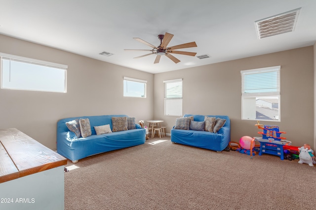 carpeted living room with ceiling fan