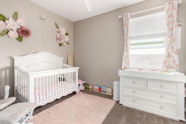 carpeted bedroom featuring a nursery area